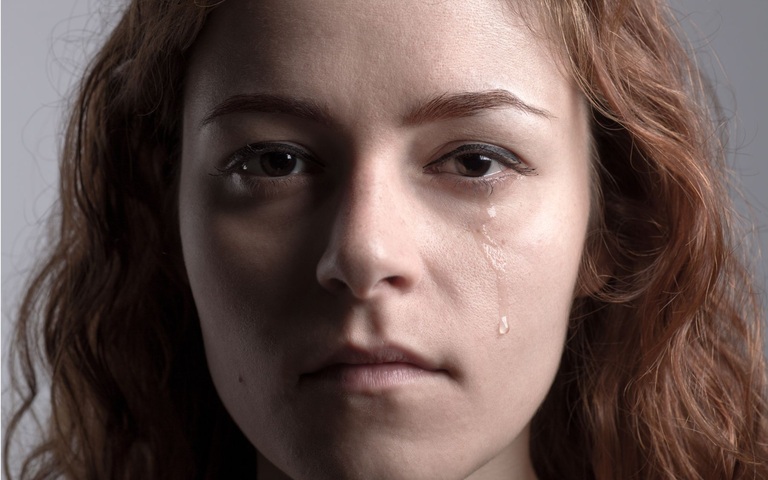 eine junge Frau, mit Tränen der Verzweiflung